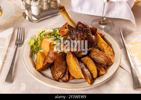 Lammbraten mit gebratenen Kartoffeln auf dem Restauranttisch Stockfoto