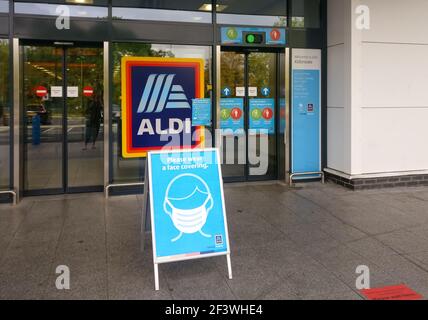 London, Vereinigtes Königreich - 21. August 2020: Tafel mit blau-weißer Anzeige, die Leute dazu auffordert, Gesichtsmaske beim Einkaufen vor dem Aldi Supermarkt zu tragen Stockfoto