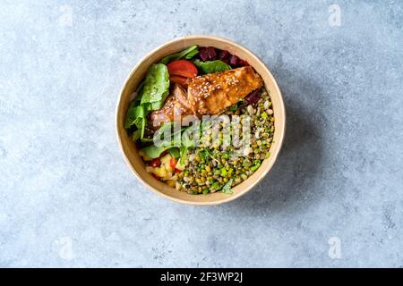 Nehmen Sie gesunde Poke Bowl mit Lachs, Mungbohnen in Take Out Plastic Bowl. Bereit zum Essen. Stockfoto