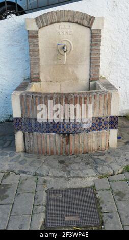 Trinkwasserbrunnen mit dekorativer Fliesenfront zur Verwendung durch Einheimische im andalusischen Dorf Stockfoto