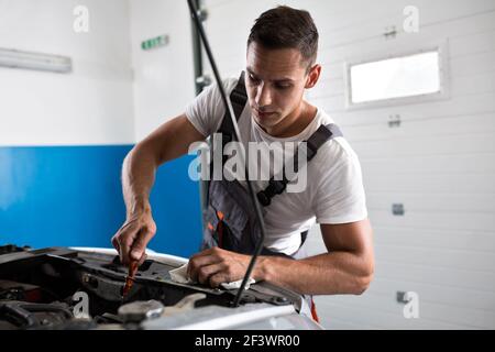 Mechaniker prüft das Öl im Auto Stockfoto