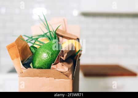 Spendenbox mit gesunder Nahrung auf weißem Küchenhintergrund. Speicherplatz kopieren. Lebensmittelzustellung während einer Coronavirus-Pandemie. Online-Shopping. Essen Stockfoto
