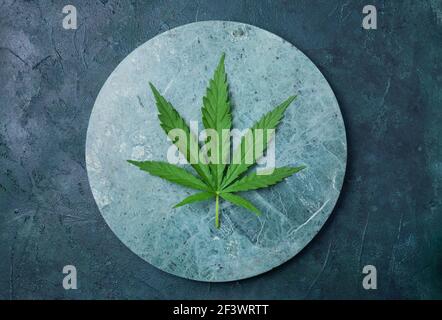 Grünes Hanfblatt auf Marmorhintergrund. Draufsicht, Kopierbereich. Nahaufnahme eines Cannabisblatts Stockfoto