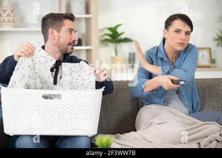 Faule Frau mit Fernbedienung versucht, tv zu sehen Stockfoto