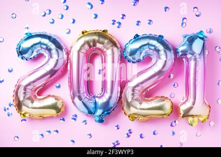 Bunte Folienballons machten Zahlen 2021 auf rosa Hintergrund mit hellen Bokehs. Frohes neues Jahr Feier Partei. Grüße und Gratulation Konzept Stockfoto