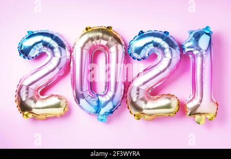 Bunte Folienballons machten Zahlen 2021 auf rosa Hintergrund mit hellen Bokehs. Banner, Kopierbereich. Frohes neues Jahr Feier Partei. Grüße und Stockfoto