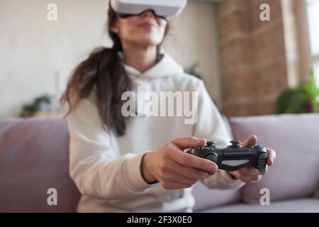 Junge Frau in vr Brille drücken Tasten auf Joystick während Ihr virtuelles Spiel Stockfoto