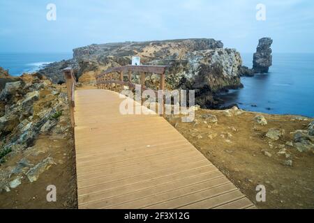 Eine lange Exposition Seestück und Holzbrücke Gehweg in Carvoeiro Kap an einem nebligen Morgen, Atlantikküste, Portugal Stockfoto