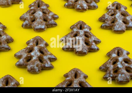 Weihnachtsbaum-Kekse auf Holzhintergrund. Neujahrsessen. Festliche Backwaren. Lebkuchen auf dem Tisch. Puderzucker Süße Geschmack Saison. Muster. Stockfoto