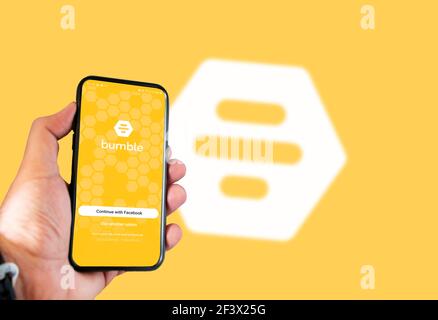 Rom, Italien, februar 16th 2021: Hand hält ein Smartphone mit Bumble Dating App Login-Seite auf dem Bildschirm mit unscharfen Bumble Logo auf dem Hintergrund. Sozial Stockfoto