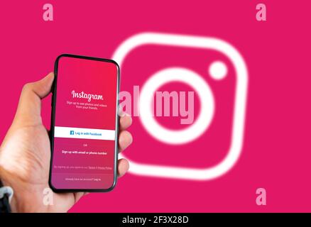 Rom, Italien, februar 16th 2021: Hand hält ein Smartphone mit Instagram Social App Login-Seite auf dem Bildschirm und verschwommen Instagram Logo auf dem Hintergrund. So Stockfoto