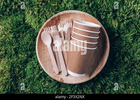 Öko Handwerk Papier Geschirr. Pappbecher, Geschirr, Beutel, Fast-Food-Behälter und Holzbesteck auf grünem Mooshintergrund. Recycling oder umweltfreundlich Stockfoto