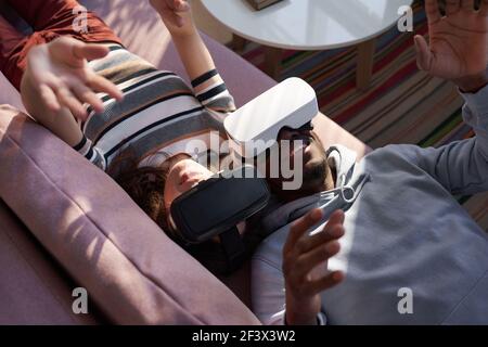 Glückliches Paar auf dem Sofa liegen und Spaß mit neuen Trends in der Technologie Stockfoto