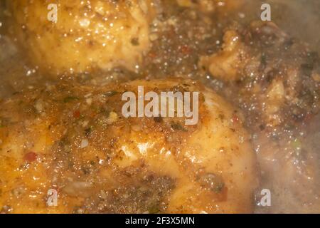 Kleine Stücke Hühnerfleisch werden mit Gewürzen geschmort. Nahaufnahme mit selektivem Fokus. Stockfoto