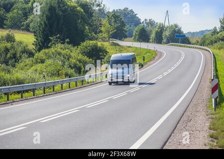 Minibus geht auf das Land Highway entlang der Wald Stockfoto