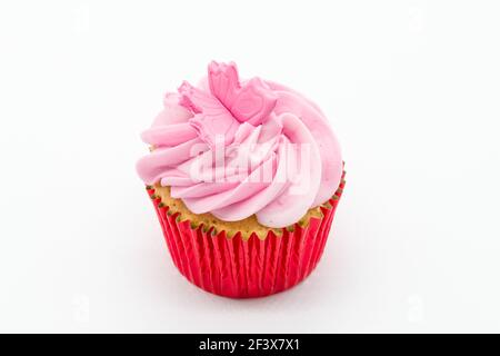 Oster-Cup-Kuchen mit rosa Vereisung und roten Schwammhüllen auf weißem Hintergrund. Stockfoto