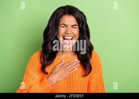 Foto von ziemlich charmanten dunklen Haut Dame gekleidet Strickpullover Lachende Arm Brust isoliert grüne Farbe Hintergrund Stockfoto