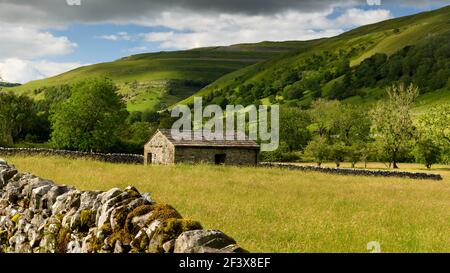 Schöne sonnige Wharfedale Landschaft (Tal, Hänge, Feldscheune, Trockenmauern, Ackerland Weiden, High Hills) - Yorkshire Dales, England, Großbritannien. Stockfoto