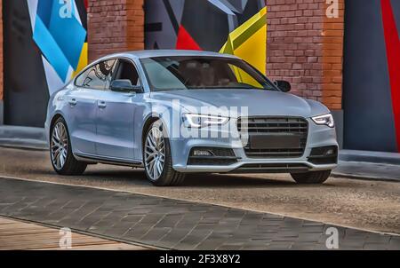Modernes Luxusauto bewegt sich auf der Straße in der Stadt Am Abend Stockfoto