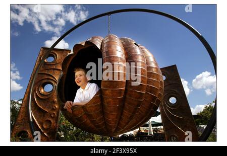 Letzte min Vorbereitung bei der Hampton Court Palace Flower Show.......öffentlich zugänglich 6-11 Juli 2004.pic David Sandison 5/7/2004 der junge Jonathan Burns genießt einen Giant Pumpkin Swing von Fletcher & myburgh bei der Hampton Court Palace Flower Show......öffentlich zugänglich 6-11 Juli 2004. Pic David Sandison 5/7/2004 Stockfoto