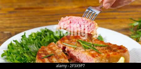 Thunfischsteak auf dem elektrischen Grill gekocht. Thunfisch serviert auf einem Teller mit frischen Kräutern und Gemüse. Gesunde nahrhafte, gesunde Ernährung für eine gesunde Stockfoto