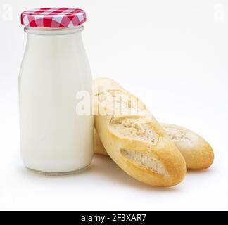 Flasche Milch und Brote (Baguettes), Kopierraum. Vorderansicht. Isoliert auf weißem Hintergrund. Stockfoto