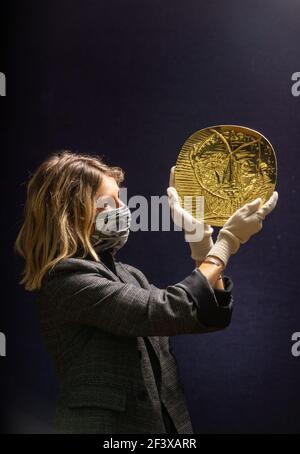 Ein Bonhams-Mitarbeiter hält "Visage de Faune", eine 22-Karat-Goldplatte repoussŽ von Pablo Picasso und Goldschmied Franois Hugo, die eine Schätzung von £250.000-350.000 bei einem Fotoanruf in Bonhams in London hat, vor dem bevorstehenden Verkauf Picassomania, der am 23. März stattfindet. Bilddatum: Donnerstag, 18. März 2021. Stockfoto
