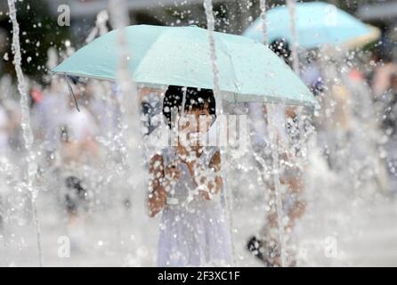 OLYMPISCHE SPIELE PEKING 2008. 10th TAG 18/8/08. KINDER KÜHLEN SICH IM FOUNTIANS VOR DEM STADION AB. BILD DAVID ASHDOWN Stockfoto