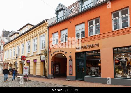 Flensburg, Deutschland - 9. Februar 2017: Altes Flensburger Straßenbild mit Menschen gehen in der Nähe von alten Häusern und Restaurants Stockfoto