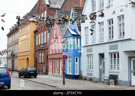 Flensburg, 10. Februar 2017: Verlassene Schuhe hängen an einem Draht über der Straße. Flensburg, Deutschland Stockfoto