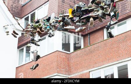 Flensburg, Deutschland - 10. Februar 2017: Viele verlassene Schuhe hängen an einem Draht über der Straße Stockfoto