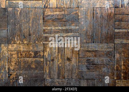 Altes Holz abgenutztes Parkett Nahaufnahme, Hintergrund mit Rissen und Kratzern, aus kleinen braunen Brettern. Struktur und Muster Stockfoto