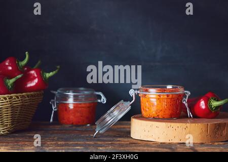 Geröstete Paprika genießen (Ajvar) in Gläsern auf dem Tisch Stockfoto