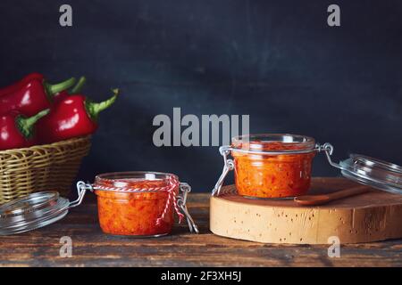 Geröstete Paprika genießen (Ajvar) in Gläsern auf dem Tisch Stockfoto