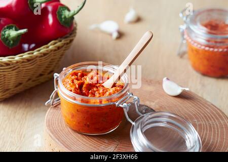 Geröstete rote Paprika genießen (Ajvar) in einem Glas mit Zutaten Stockfoto