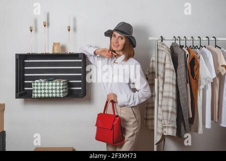 Frau Stylistin versucht auf moderne Business-Kleidung mit einem roten Tasche Stockfoto