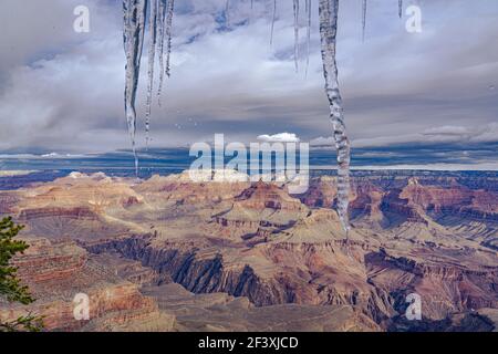 Die Eiszapfen auf dem Fensterrahmen auf dem Hintergrund von Die wunderschöne Landschaft des Grand Canyon Stockfoto