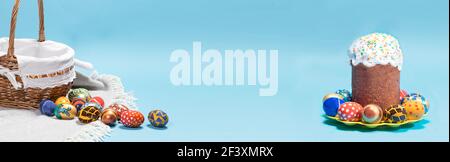 Ein gratulatorisches blaues Banner mit einem Osterkuchen, einem Korb und Eiern mit Platz für Text. Stockfoto