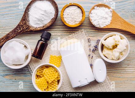 Herstellung hausgemachter Deodorant Stick mit allen natürlichen Zutaten Konzept. Blauer Holzhintergrund. Pfeilwurzelpulver, Backpulver, Bienenwachs, Sheabutter. Stockfoto