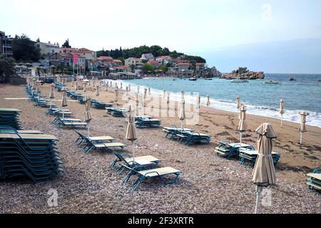 Einsamer Strand mit Liegestühlen und Sonnenschirmen in der Nähe des Meeres. Herbst in Montenegro. Stockfoto