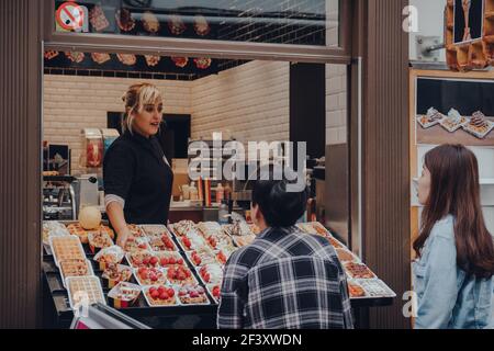 Brüssel, Belgien - 16. August 2019: Mitarbeiter und Touristen in einem traditionellen belgischen Waffelgeschäft in Brüssel, selektiver Fokus. Stockfoto