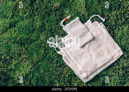 Canvas-Tragetasche Canvas, Leinenstofftaschen mit Kordelzug auf grünem Gras, Mooshintergrund. Draufsicht. Kein Abfall, Kunststoff-freies Konzept. Umweltfreundlich Stockfoto