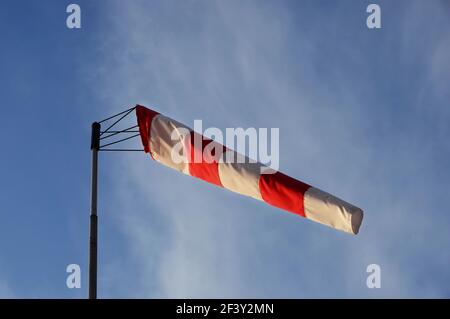 Ein Windkegel Wetterfahne an windigen Tag mit blauem Himmel im Hintergrund. Stockfoto