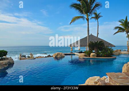 One&Only Palmilla Luxus Resort Poolblick und Reetdach Open-Air Pool Bar mit Blick auf das Meer von Cortés in San José del Cabo, Mexiko. Stockfoto