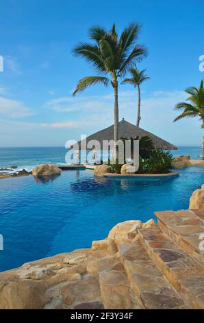 One&Only Palmilla Luxus Resort Poolblick und Reetdach Open-Air Pool Bar mit Blick auf das Meer von Cortés in San José del Cabo, Mexiko. Stockfoto