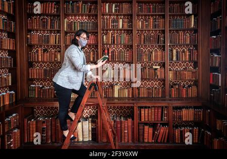 Die Sammlungsmanagerin Dr. Hannah Thomas mit einem Buch aus der historischen Bibliothek des ältesten lebenden Klosters Englands, Bar Convent in York, bereitet sich darauf vor, die seltene historisch bedeutsame Bibliothek der Welt zu enthüllen. Bilddatum: Donnerstag, 18. März 2021. Stockfoto