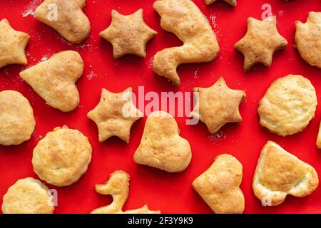 Flach oben über dem Blick auf süß lecker leckeren Quark Ingwerkekse gebacken im heißen Ofen auf rot hell Silikon Backmatte in der Küche zu Hause Stockfoto