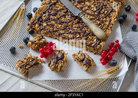 Hausgemachter Proteinriegel mit Getreide, Molkenproteinpulver, Nüssen und Honig. Serviert auf einem Backblech von oben mit Kopierplatz Stockfoto