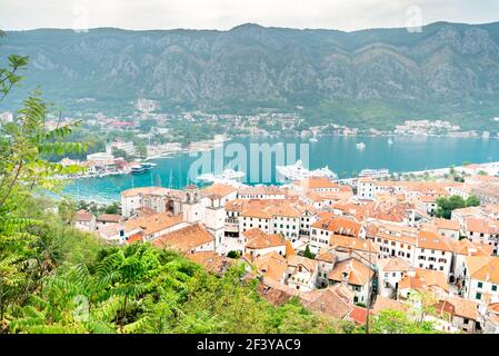 Blick über die Bucht von Kotor und die Terrakotta-Dächer der Altstadt und das ruhige kobaltblaue Wasser und die Berge dahinter. Stockfoto