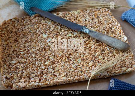 Keine Müsliriegel mit Nüssen, Samen, gepufftem Haferflocken, Amaranth, Honig und Ahornsirup auf einem Holztisch serviert Stockfoto